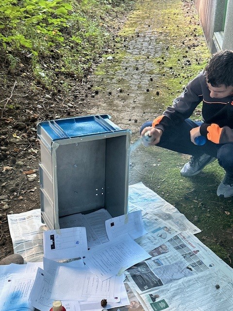 Pascal an der Kiste sprayen